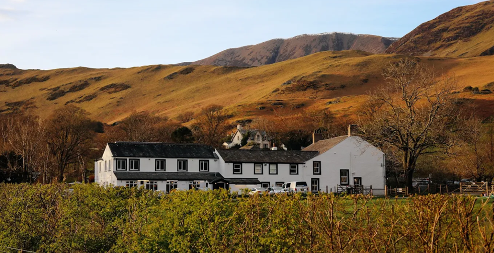 Comfortable accommodation at the Buttermere Hotel, set against a stunning mountain backdrop on a self-guided adventure route.